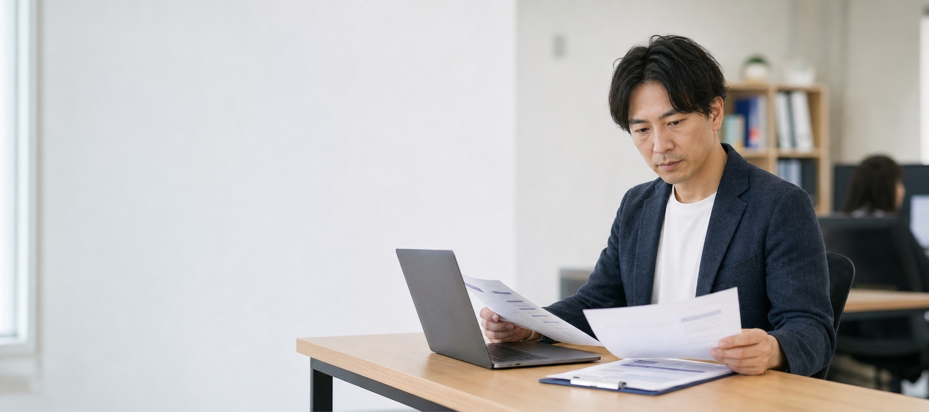 案件情報とスキルシートを見比べる人材会社の営業担当
